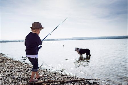 dog standing on person - Boy fishing with dog in creek Stock Photo - Premium Royalty-Free, Code: 649-06040821