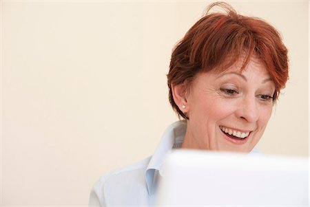 Smiling woman using laptop Stock Photo - Premium Royalty-Free, Code: 649-06040955