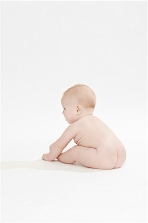 Nude baby boy sitting on floor Stock Photo - Premium Royalty-Free, Code: 649-06040986