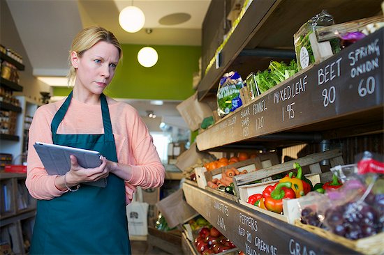 Grocer using tablet computer in store Stock Photo - Premium Royalty-Free, Image code: 649-06041023