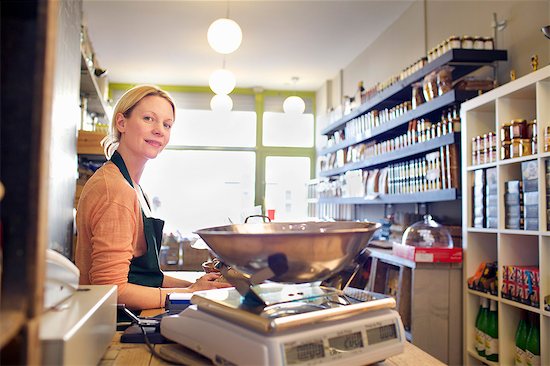 Grocer working behind counter at store Stock Photo - Premium Royalty-Free, Image code: 649-06041036