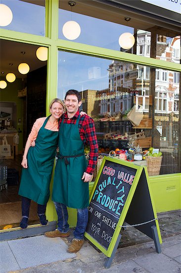 Smiling grocers standing outside store Stock Photo - Premium Royalty-Free, Image code: 649-06041040