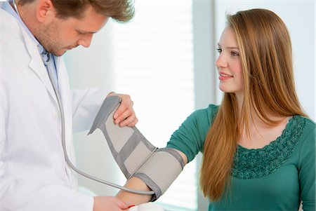 doctor patient services - Doctor taking girls blood pressure Foto de stock - Sin royalties Premium, Código: 649-06041105