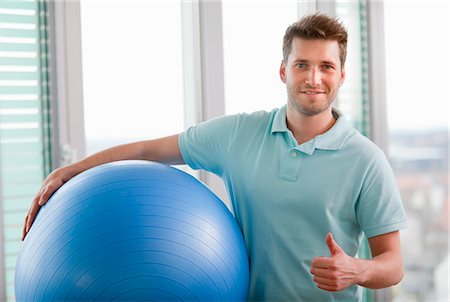 pelota de ejercicios - Man carrying exercise ball in gym Foto de stock - Sin royalties Premium, Código: 649-06041101