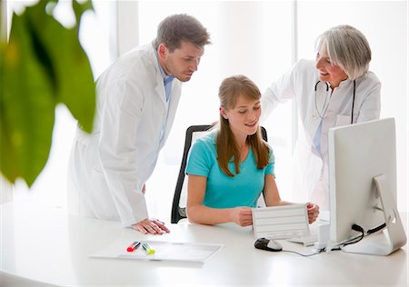 receptionist at desk - Doctors talking to receptionist Stock Photo - Premium Royalty-Free, Code: 649-06041123