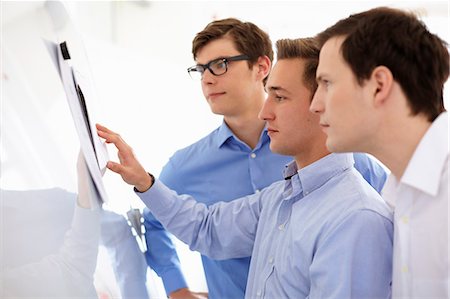 Businessmen reading together in office Stock Photo - Premium Royalty-Free, Code: 649-06041148