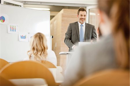 seminar smiling - Businessman hosting seminar in office Stock Photo - Premium Royalty-Free, Code: 649-06041268