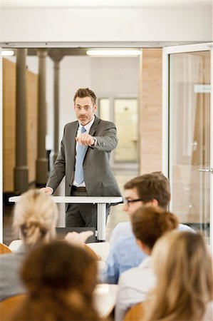 simsearch:649-09206149,k - Businessman hosting seminar in office Fotografie stock - Premium Royalty-Free, Codice: 649-06041262