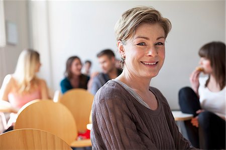 portrait caucasian young adult group happy - Older student smiling in classroom Stock Photo - Premium Royalty-Free, Code: 649-06041278