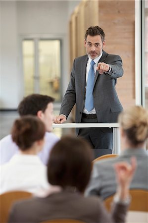 question - Businessman hosting seminar in office Stock Photo - Premium Royalty-Free, Code: 649-06041271