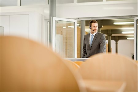 Businessman wearing headset at podium Stock Photo - Premium Royalty-Free, Code: 649-06041283