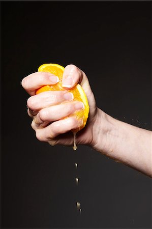 Hand squeezing orange Foto de stock - Sin royalties Premium, Código: 649-06041478