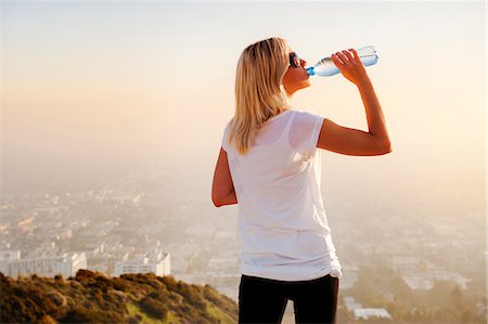 Woman drinking water on hilltop Foto de stock - Sin royalties Premium, Código: 649-06041486