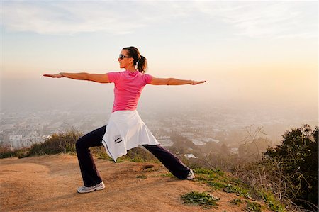 standing - Woman stretching on hilltop Stock Photo - Premium Royalty-Free, Code: 649-06041489
