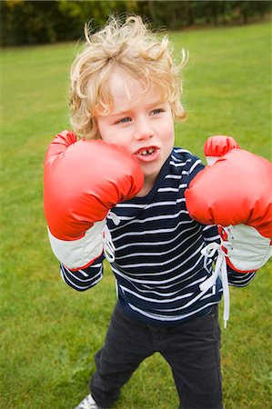 Boy playing with boxing gloves outdoors Stock Photo - Premium Royalty-Free, Code: 649-06041781