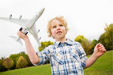 Boy playing with toy airplane outdoors Stock Photo - Premium Royalty-Free, Code: 649-06041790