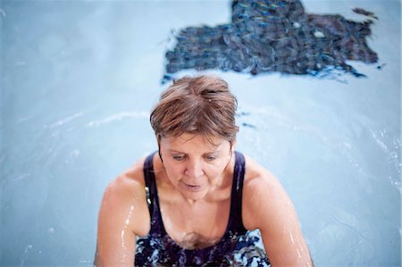 senior woman and swimsuit - Woman splashing in swimming pool Stock Photo - Premium Royalty-Free, Code: 649-06042070