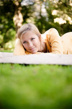 simsearch:649-03666028,k - Woman laying on blanket in park Fotografie stock - Premium Royalty-Free, Codice: 649-06112538