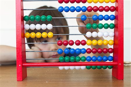 Boy playing with abacus Foto de stock - Royalty Free Premium, Número: 649-06112570