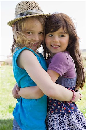 Filles souriantes s'enlaçant à l'extérieur Photographie de stock - Premium Libres de Droits, Code: 649-06112590