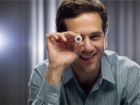 Businessman holding glass eye Stock Photo - Premium Royalty-Free, Code: 649-06112637