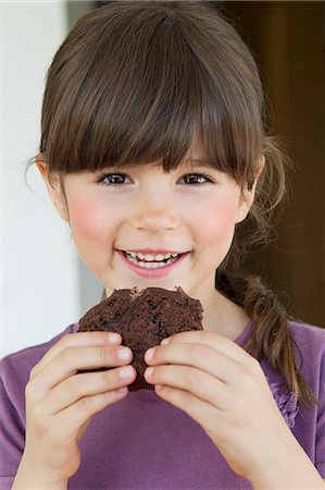 foods kids - Close up of smiling girl eating brownie Stock Photo - Premium Royalty-Free, Code: 649-06112630