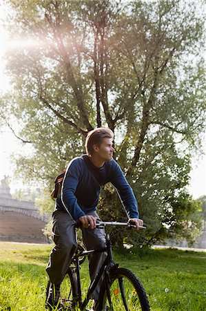 simsearch:649-06112676,k - Man riding bicycle in field Stock Photo - Premium Royalty-Free, Code: 649-06112678