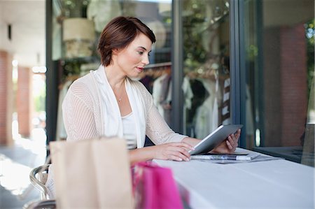 simsearch:6122-07706757,k - Woman using tablet computer in cafe Stock Photo - Premium Royalty-Free, Code: 649-06112777