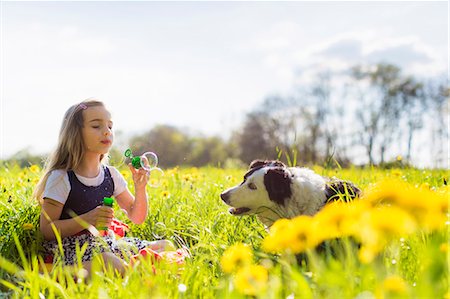 dog free outside - Girl blowing bubbles with dog in field Stock Photo - Premium Royalty-Free, Code: 649-06112835