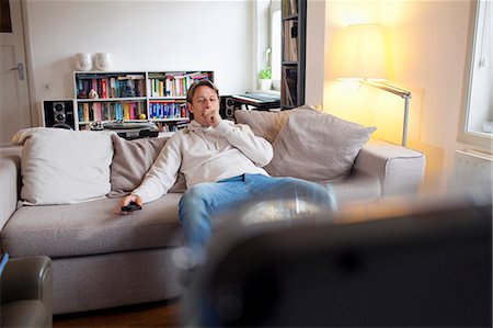 Man yawning in front of television Stock Photo - Premium Royalty-Free, Code: 649-06112956