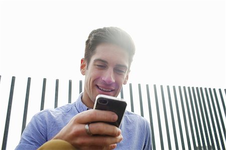 Man using cell phone on city street Stock Photo - Premium Royalty-Free, Code: 649-06113005