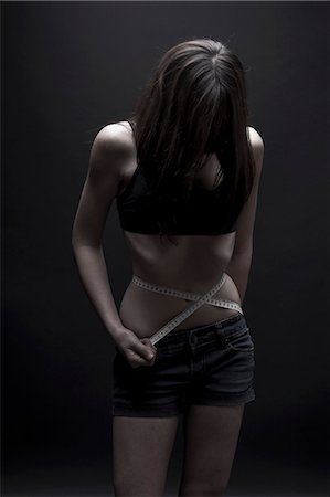 female sports bra - Teenage girl measuring her waist Stock Photo - Premium Royalty-Free, Code: 649-06113069
