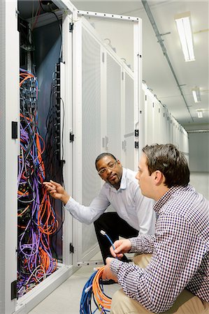 data center business - Businessmen examining wires in server Stock Photo - Premium Royalty-Free, Code: 649-06113264