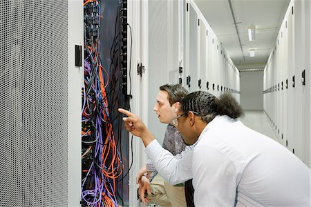 Businessmen examining wires in server Foto de stock - Sin royalties Premium, Código: 649-06113263