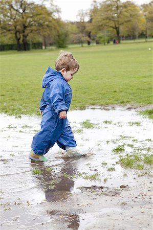 Toddler boy walking in puddle Foto de stock - Sin royalties Premium, Código: 649-06113425