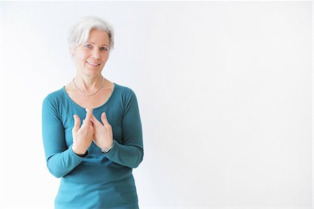 silver hair smile alone - Smiling woman gesturing with hands Stock Photo - Premium Royalty-Free, Code: 649-06113680