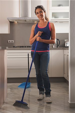 escoba - Smiling woman cleaning kitchen floor Foto de stock - Sin royalties Premium, Código: 649-06113768