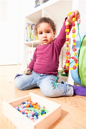 Girl playing with string of wooden beads Foto de stock - Sin royalties Premium, Código: 649-06113799