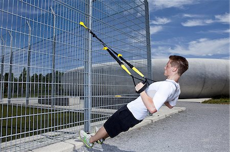 resistance band and men - Man working out in industrial area Stock Photo - Premium Royalty-Free, Code: 649-06113790