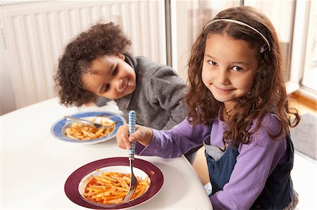 simsearch:649-03291674,k - Girls eating pasta together at table Stock Photo - Premium Royalty-Free, Code: 649-06113804