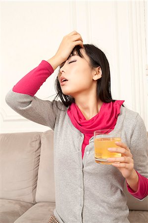 drinking problem - Woman drinking juice on couch Stock Photo - Premium Royalty-Free, Code: 649-06164322