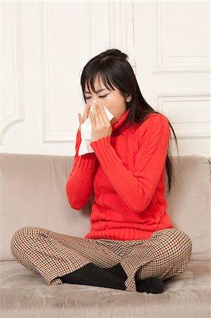 estornudar - Woman blowing her nose on couch Foto de stock - Sin royalties Premium, Código: 649-06164323