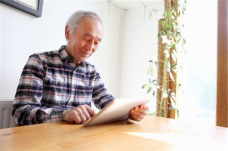 Older man using tablet computer at table Stock Photo - Premium Royalty-Free, Code: 649-06164489