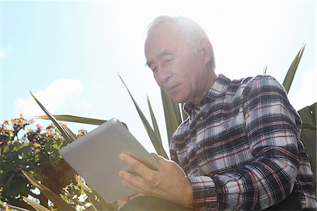 east asian garden - Older man using tablet computer outdoors Stock Photo - Premium Royalty-Free, Code: 649-06164491