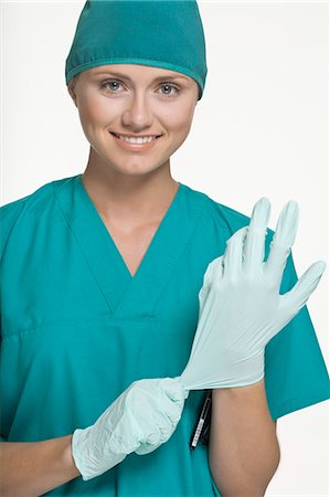 simsearch:6122-07707369,k - Surgeon pulling on latex gloves Fotografie stock - Premium Royalty-Free, Codice: 649-06164644