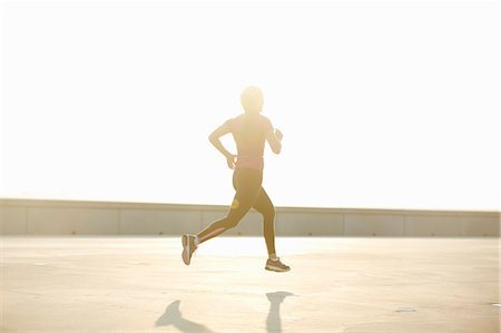 running people silhouette - Man running on rooftop Stock Photo - Premium Royalty-Free, Code: 649-06164816