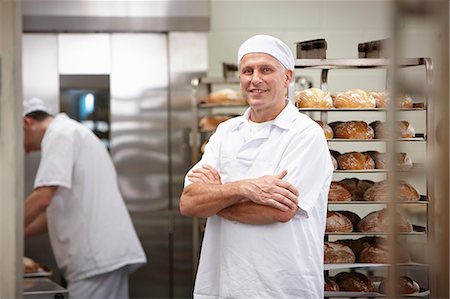Smiling chef standing in kitchen Foto de stock - Sin royalties Premium, Código: 649-06165023