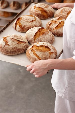 simsearch:649-06165040,k - Chef portant plateau de pain dans la cuisine Photographie de stock - Premium Libres de Droits, Code: 649-06165036