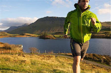 Hiker running up grassy hillside Foto de stock - Sin royalties Premium, Código: 649-06165054