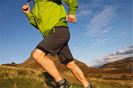 side view male joggers - Hiker running up grassy hillside Stock Photo - Premium Royalty-Free, Code: 649-06165056